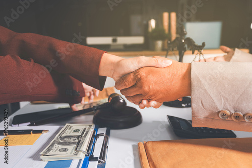 Judge gavel with Justice lawyers having team meeting at law firm in background. Notary with client in office