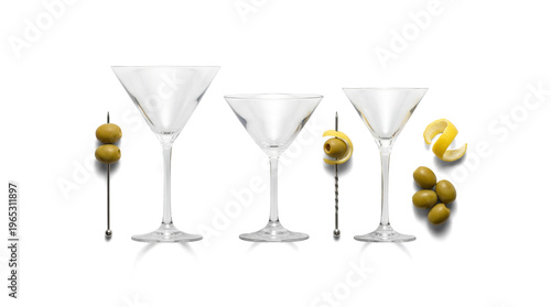 Tableau sur toile Elegant clear empty martini glasses, perfectly poised with classic green olive and vibrant lemon twist garnishes