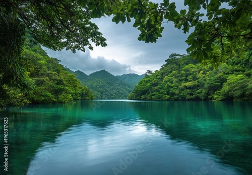 Tranquil Turquoise Lake Surrounded by Lush Tropical Rainforest and Misty Mountains