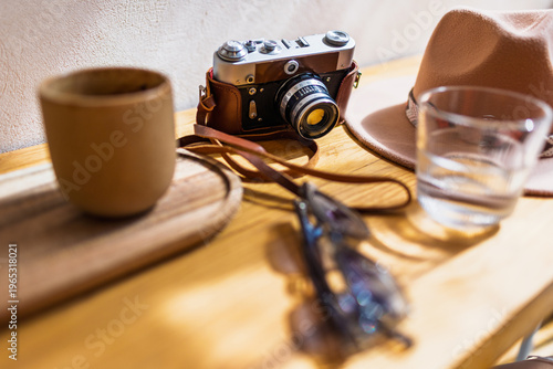 Obraz na płótnie A camera, coffee, and a hat are on the table