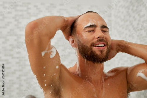 Man taking a shower and shampooing hair