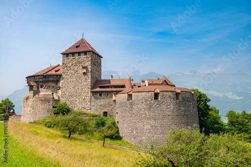 Vaduz Castle in Liechtenstein with alpine mountains and historic architecture on a sunny day