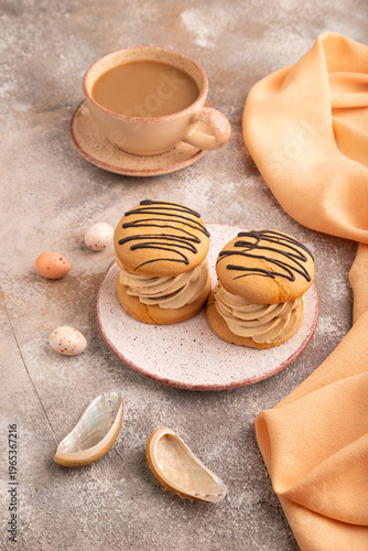 Caramel Cream Cakes on brown concrete, cup of coffee, side view, close up