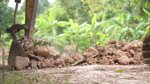 Earthmover at Work: A close-up showcases the power of an earthmover as it diligently excavates soil, the machinery's scoop filled with earth, illustrating the raw power of the industrial world.