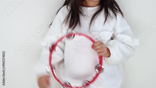 タンバリンで音を出す女の子（5歳、日本人、顔無し）