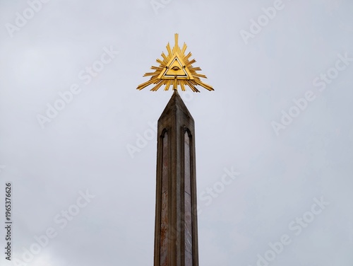 Foto Minimalist obelisk with golden symbol above
