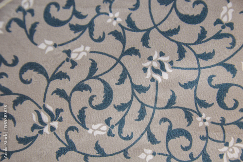 Vintage floral pattern on fabric texture. Elegant blue and white leaf vine motif on gray textile background. Classic ornamental design for fashion and decor.