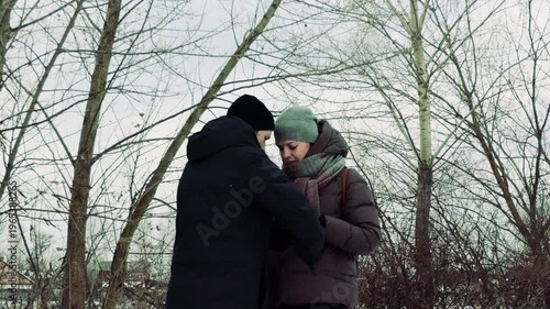 Young Couple in Warm Winter Clothing Sharing a Gentle Moment in a Cold Outdoor Park