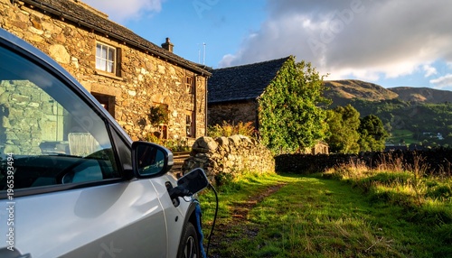 Electric Vehicle Charging Outside a Traditional Stone Cottage in the Lake District at Sunset