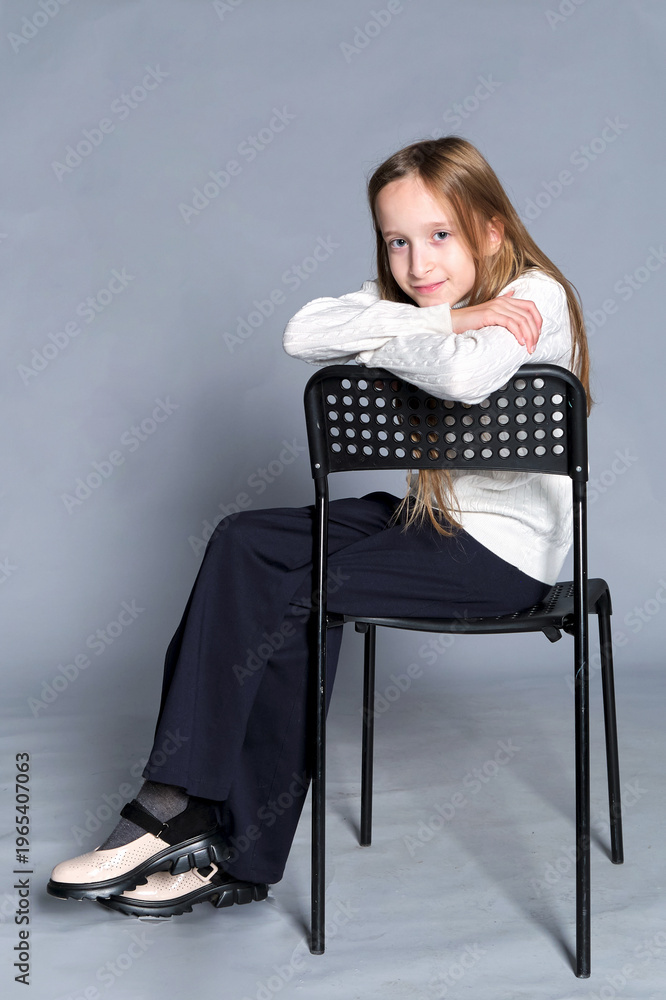 Fototapeta premium A peaceful scene, with a child leaning on a chair, exuding serenity and a homely feel.