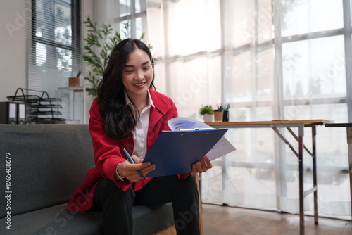 Woman smiling managing documents holding clipboard in office