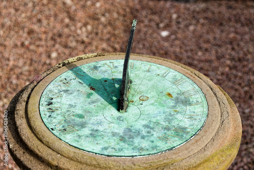 Foto A close-up shot of a vintage weathered sundial made of bronze or copper with a distinct turquoise verdigris patina