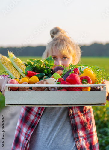 A woman farmer holds vegetables in her hands. Selective focus.
