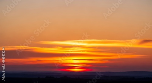 Vivid Sunset Sky Over Distant Horizon With Dramatic Golden Clouds and Vibrant Orange and Red Tones