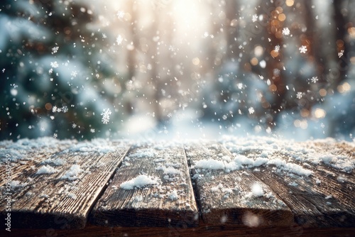 Wooden table covered in snow with a blurred forest background and falling snowflakes