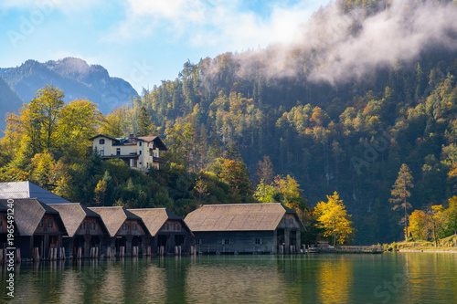 Boathouses at Königssee in Berchtesgaden National Park, Germany with autumn forest and misty mountains