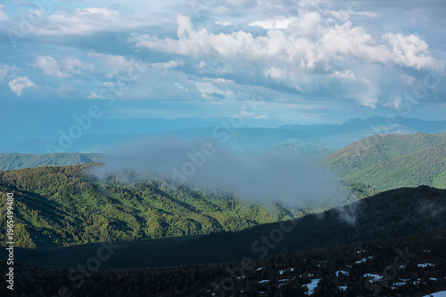 Scenic aerial top view from above to low rainy cloud above forest valley in s...