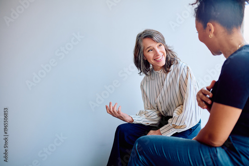 Foto Two professional women engaging in a friendly business conversation, actively li