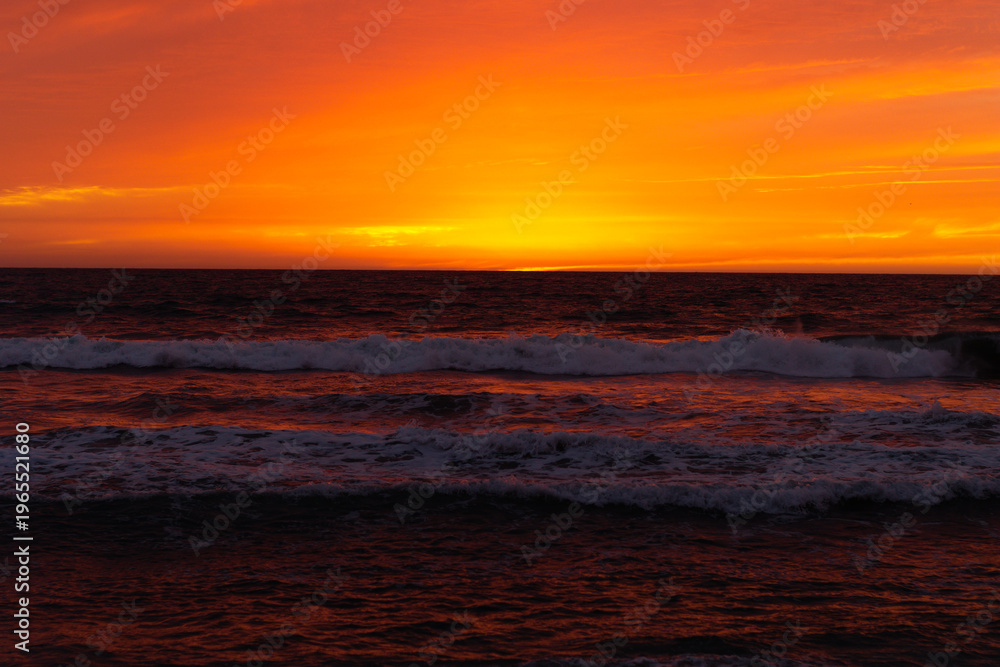 Fototapeta premium Bright Orange Sunset Over Pacific Ocean Waves California