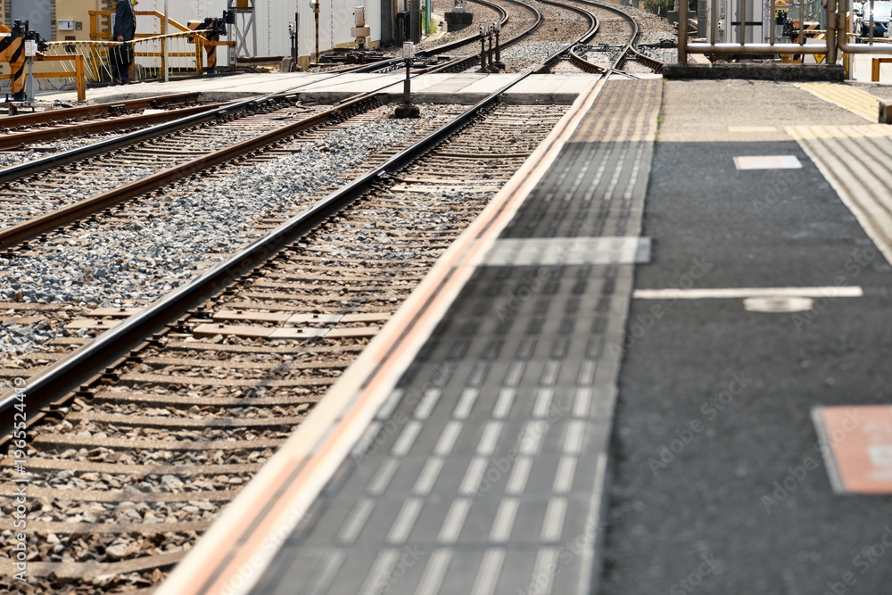 Naklejka premium 鉄道駅のホーム縁と線路のクローズアップ 公共交通インフラ、通勤の日常、安全と境界線を象徴するコンセプトイメージ