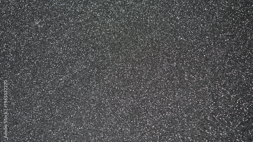 Fototapeta premium Textured black surface with fine glitter particles creating a shimmering effect