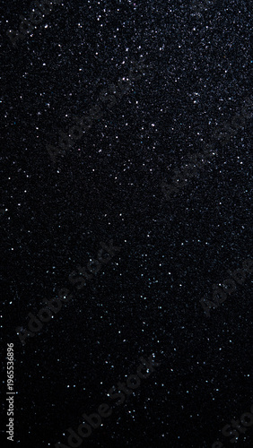 Black glitter texture background with sparkling particles for design and creative projects