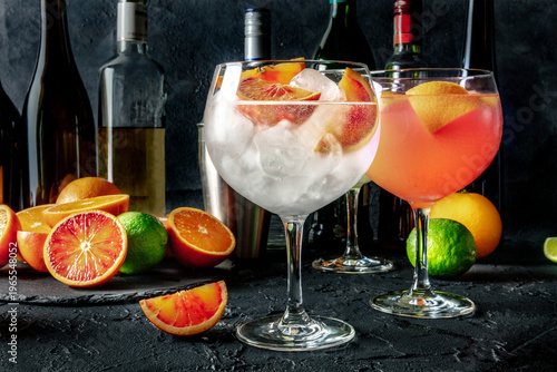 Wallpaper Mural Gin Tonic cocktail in a copa glass at a bar, with oranges and pink grapefruit, side view on a dark background Torontodigital.ca