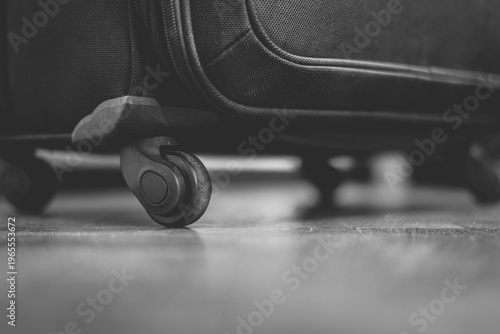 Suitcase wheel resting on floor in black and white