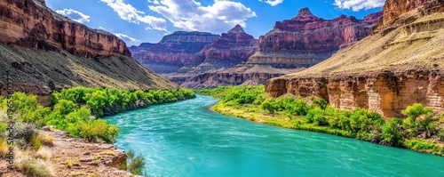 Turquoise river flowing between massive stratified canyon walls under  bright blue sky