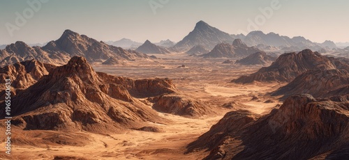 Vast, panoramic landscape showing rocky, eroded mountains and desert plains under a hazy, warm sky