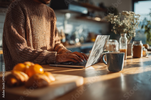 Creative professional working on laptop in cozy kitchen.