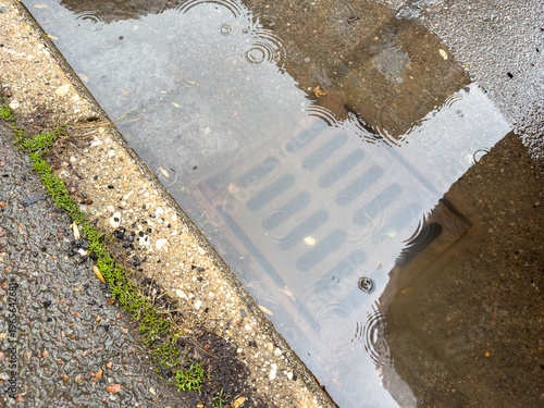 Rain water flows up out of clogged drain cover