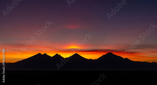Vibrant Sunset Over Mountain Silhouettes with Dramatic Color Gradient Sky