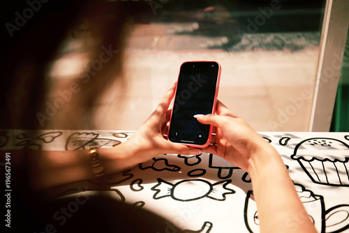 Young adult hands holding modern smartphone. mockup social media browsing, workspace, online interaction, mobile device marketing, freelance content creator. Person using a smartphone with a pink case