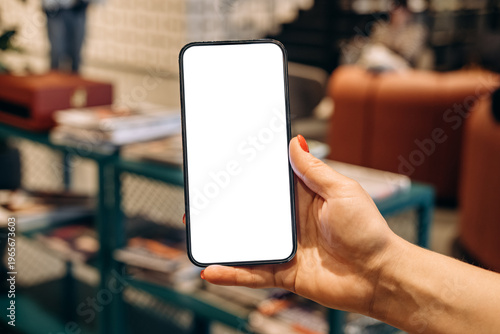 Mockup woman's hand holding using smart phone with white blank screen POV , mobile app design and advertising, online marketing
