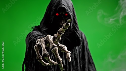 Grim Reaper with glowing red eyes reaching out on green screen.