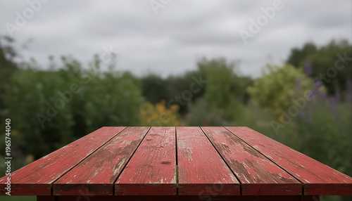 Red wooden table mockup with blurred garden background
