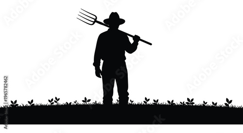 Farmer with pitchfork stands in field a striking silhouette