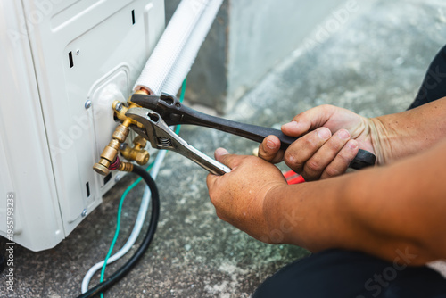Quadro su tela Air conditioner technician hands using wrenches to tighten flare nut on outdoor