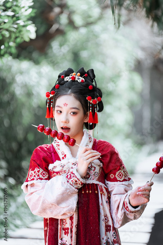 The girl in hanfu holds Tomatoes on sticks