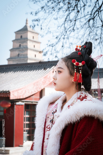 A woman dressed in Hanfu stands in front of the Big Wild Goose Pagoda in Xi'an