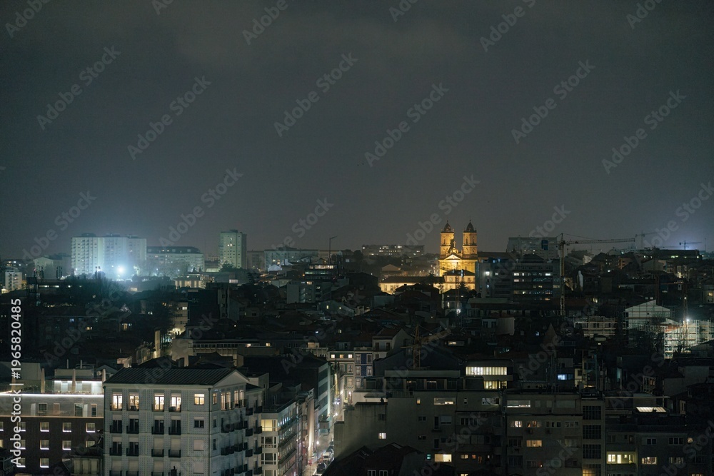 Obraz premium Bright lights illuminate Porto's skyline as digital nomads adapt to life in this vibrant city amidst rising housing prices and economic challenges. The night reveals a blend of history and modernity
