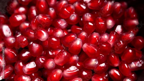 Macro shot of fresh ripe pomegranate seeds with vibrant red color and juicy texture in bowl. Antioxidants source. Superfood ingredient. Rotation