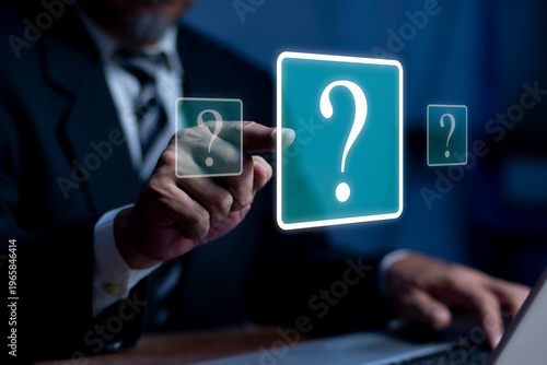 Businessman working on laptop pointing glowing question mark icon. asking questions, FAQ, customer support, consulting and digital business technology.
