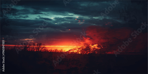A beautiful dramatic sunset creates a fire in the sky over mountain peaks where orange and red clouds meet the horizon in a stunning nature landscape at dusk