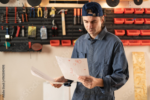 Billede på lærred Carpenter man reading installation instruction paper for assembly furniture in c
