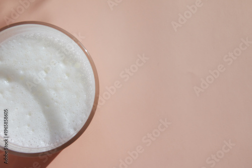 glass of milk on pink background