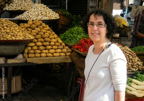 Friendly woman stands proudly among fresh produce in bustling outdoor market