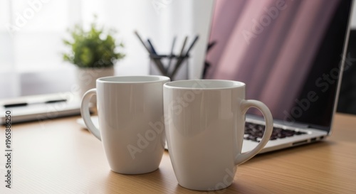Plain White Mugs Wait on a Light Wooden Desk, Positioned Near a Modern Silver Laptop, a Green Potted Plant, and Office Supplies in a Brightly Lit Room for Productive Work