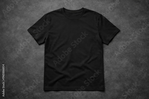 Plain Black Cotton T-Shirt With Short Sleeves Laid Flat on a Dark Grey Textured Concrete Surface, Showing Natural Wrinkles and a Simple Crew Neck Design, Ready for a Custom Print or Logo Mockup
